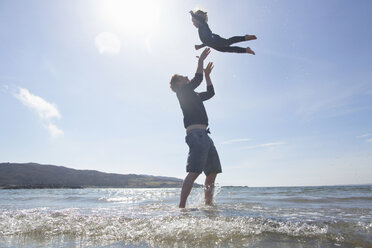 Vater wirft Sohn am Strand in die Luft, Loch Eishort, Isle of Skye, Hebriden, Schottland - CUF27287