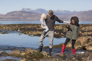 Vater hält seinen Sohn am Loch Eishort, Isle of Skye, Hebriden, Schottland - CUF27295