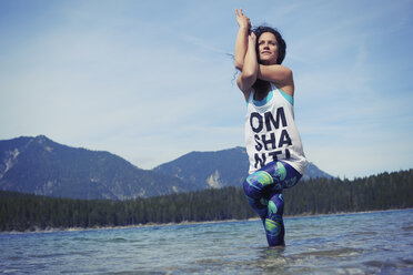 Mittlere erwachsene Frau, stehend im See, in Yogaposition, Tiefblick - CUF27329