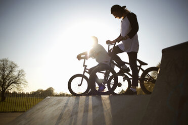 Two young men on bmx bikes at skatepark - CUF27356