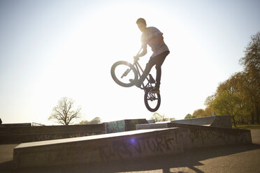 Young man, in mid air, doing stunt on bmx at skatepark - CUF27357
