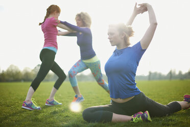 Three women exercising and stretching in the park - CUF27362