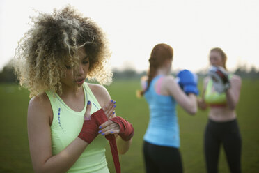 Drei Frauen trainieren mit Boxhandschuhen im Park - CUF27363