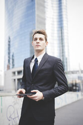 Portrait of young businessman commuter using digital tablet. - CUF27375