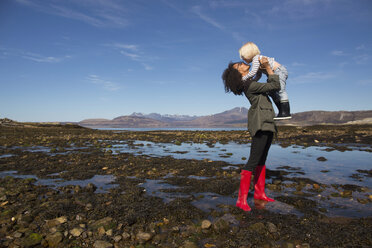 Mutter hält ihren Sohn am Loch Eishort, Isle of Skye, Hebriden, Schottland - CUF27390