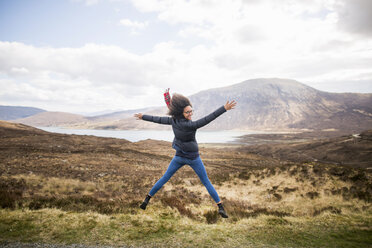 Mittlere erwachsene Frau in den Bergen beim Sternsprung, Isle of Skye, Hebriden, Schottland - CUF27394