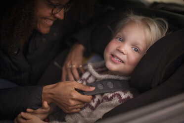 Mother adjusting son's seatbelt in car - CUF27408