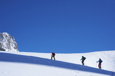 Scherenschnittansicht von drei Skifahrern, die das Mont-Blanc-Massiv hinauffahren, Graue Alpen, Frankreich - CUF27411