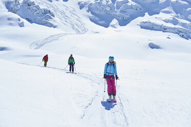 Reihe von drei erwachsenen Skifahrern, die das Mont-Blanc-Massiv hinunterfahren, Graue Alpen, Frankreich - CUF27437