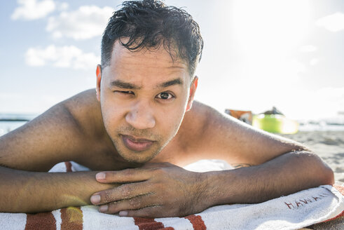 Porträt eines jungen Mannes beim Sonnenbaden am Waikiki Beach, Hawaii, USA - CUF27441