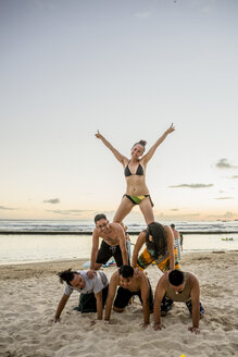 Sechs erwachsene Freunde bilden eine menschliche Pyramide am Waikiki Beach, Hawaii, USA - CUF27442