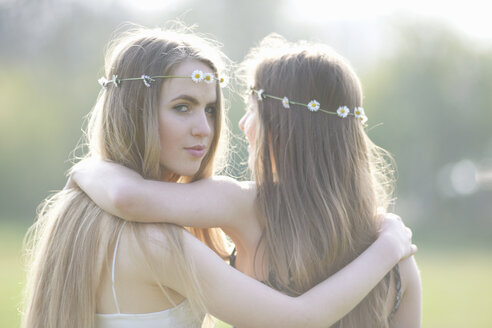 Porträt von zwei Teenager-Mädchen mit Gänseblümchen-Kopfschmuck im Park - CUF27465