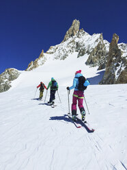 Rückansicht von drei erwachsenen Skifahrern, die das Mont-Blanc-Massiv hinauffahren, Graue Alpen, Frankreich - CUF27497