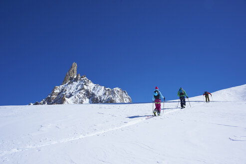 Rückansicht von drei Skifahrern, die das Mont-Blanc-Massiv hinauffahren, Graue Alpen, Frankreich - CUF27498