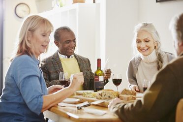 Senior friends sitting at dinner table - CUF27656