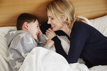 Mother and son laughing in bed - CUF27685