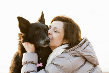 Nahaufnahme einer mittleren erwachsenen Frau, die ihren Hund küsst - CUF27692