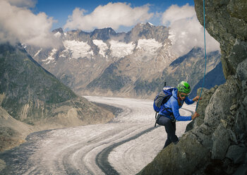 Bergsteigerin beim Klettern an der Felswand über dem Aletschgletscher, Kanton Wallis, Schweiz - CUF27713