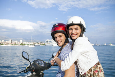 Portrait of young couple riding moped at harbour, Split, Dalmatia, Croatia - CUF27735