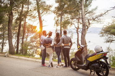 Two couples with moped looking out at sunset from coastal road, Split, Dalmatia, Croatia - CUF27742
