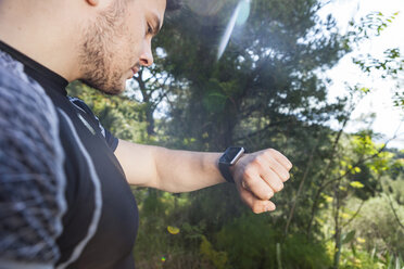 Männlicher Läufer überprüft seine Smartwatch im Park, Split, Dalmatien, Kroatien - CUF27751