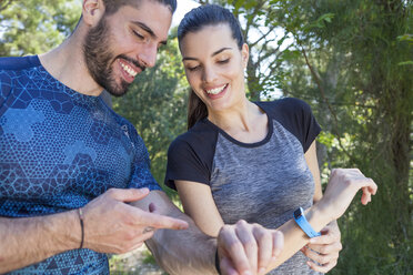 Male and female runners checking smartwatches in park, Split, Dalmatia, Croatia - CUF27756