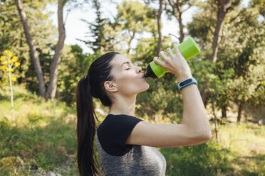 Female runner drinking water bottle in park, Split, Dalmatia, Croatia - CUF27760