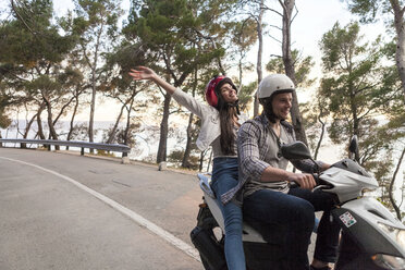 Couples riding moped on rural road, Split, Dalmatia, Croatia - CUF27767