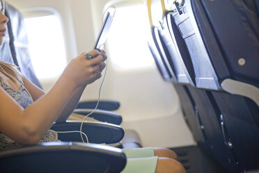 Junges Mädchen benutzt digitales Tablet im Flugzeug - CUF27781