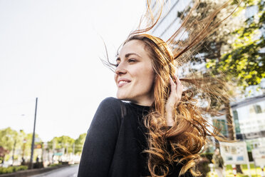 Portrait of smiling woman with blowing hair - FMKF05134