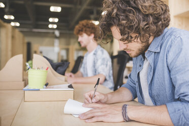 Co-workers working in open plan office - CUF27864