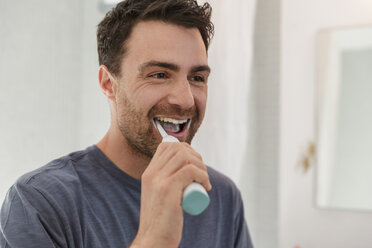 Man brushing teeth smiling - CUF27927