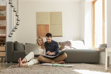 Couple with laptop looking at paperwork - CUF27934