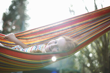 Portrait of young girl on garden hammock - CUF28036