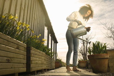 Mid adult woman watering flowers - CUF28045