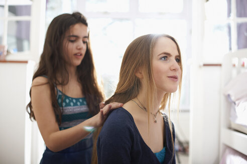 Teenager-Mädchen mit Haar plated von besten Freund im Schlafzimmer - CUF28119