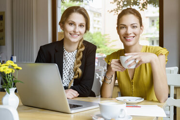 Porträt von zwei jungen Frauen beim Kaffeetrinken in einem Café - CUF28120