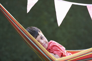 Portrait of cute boy reclining in striped garden hammock - CUF28159