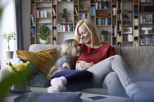 Mutter und Tochter kuscheln auf der Couch - RBF06247