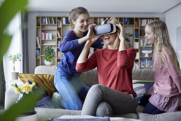 Daughters showing mother how to play with VR glasses - RBF06258