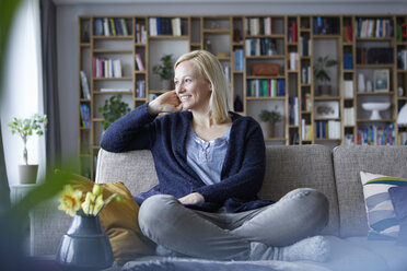 Woman relaxing at home, sitting on couch - RBF06262