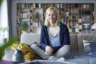 Woman relaxing at home, sitting on couch - RBF06263