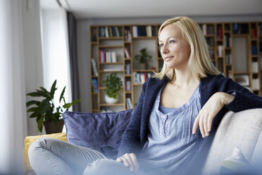 Woman relaxing at home, sitting on couch - RBF06267