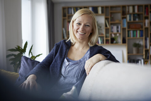 Woman relaxing at home, sitting on couch - RBF06268