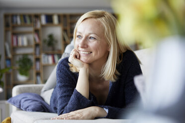 Frau entspannt sich zu Hause, sitzt auf der Couch - RBF06271