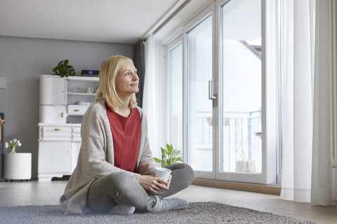 Happy woman relaxing at home, drinking coffee stock photo