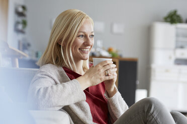 Happy woman relaxing at home, drinking coffee - RBF06291