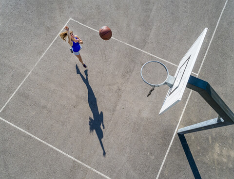 Luftaufnahme einer jungen Frau beim Basketballspielen, lizenzfreies Stockfoto