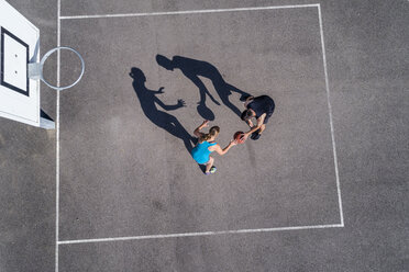 Young man and woman playing basketball, aerial view - STSF01607