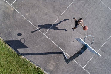 Luftaufnahme eines jungen Mannes beim Basketballspielen - STSF01609